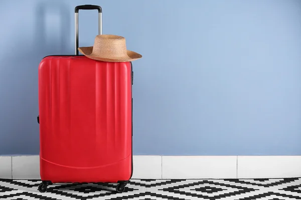 Moderner roter Koffer mit Hut — Stockfoto