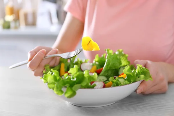 Main féminine et bol de salade de légumes — Photo