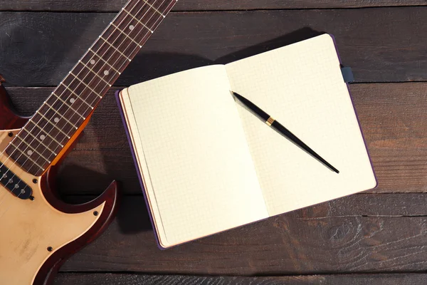 Guitar and notebook close-up — Stock Photo, Image