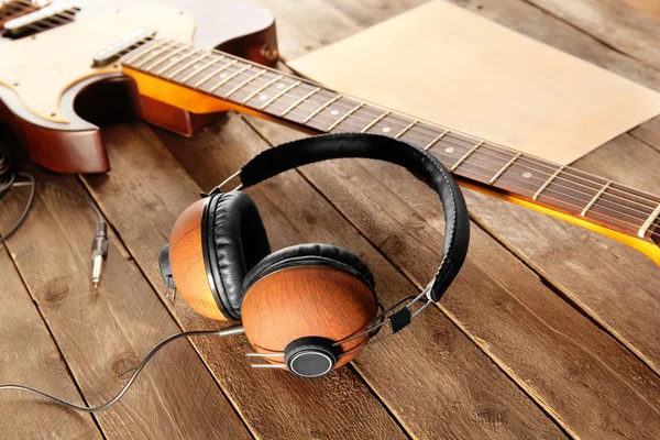 Headphones and guitar on  background — Stock Photo, Image