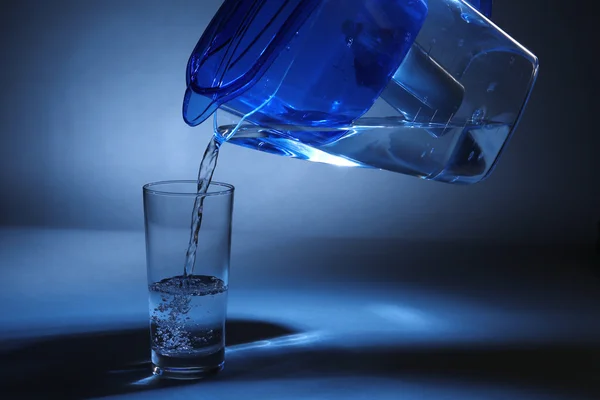 Filter jug pouring water in the glass — Stock Photo, Image