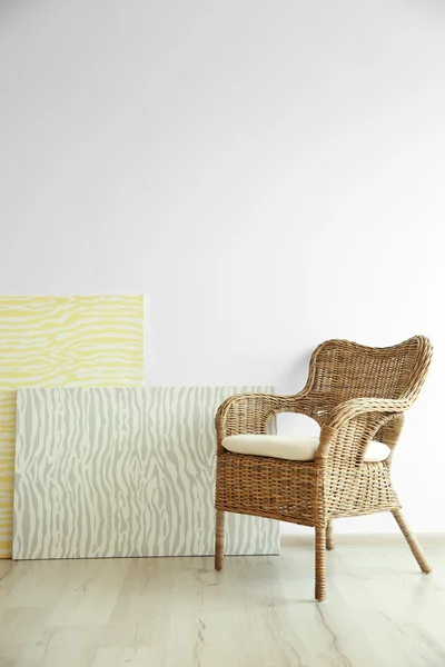 Плетеное кресло на светлой стене — стоковое фото