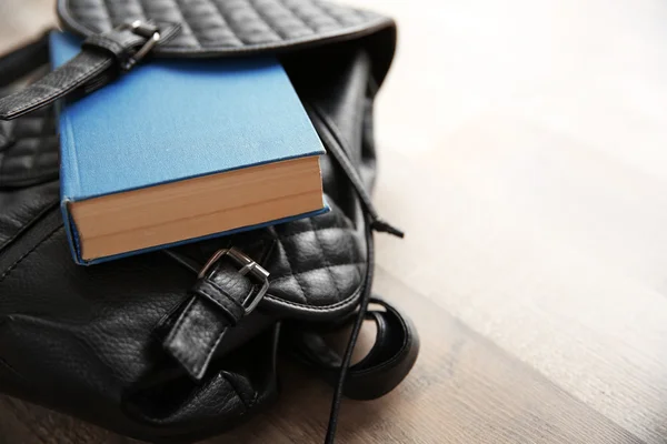 Leather backpack and book — Stock Photo, Image