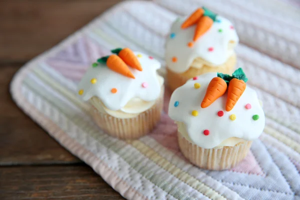 Cupcakes with frosting and decorative carrots — Stock Photo, Image