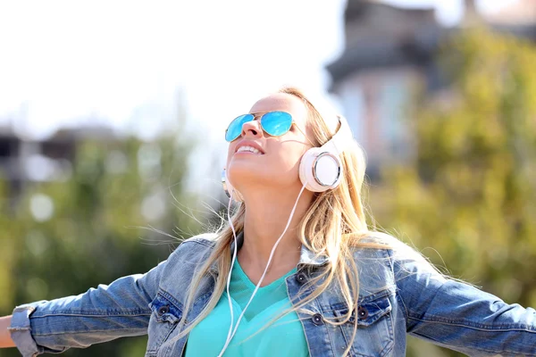 Dışarıda müzik dinleyen bir kadın. — Stok fotoğraf