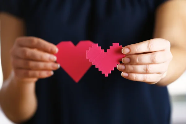 Plastikowe puzzle serca w rękach kobiet — Zdjęcie stockowe