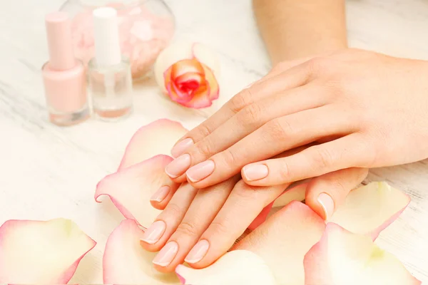 Vrouw handen met mooie roze bloemblaadjes — Stockfoto