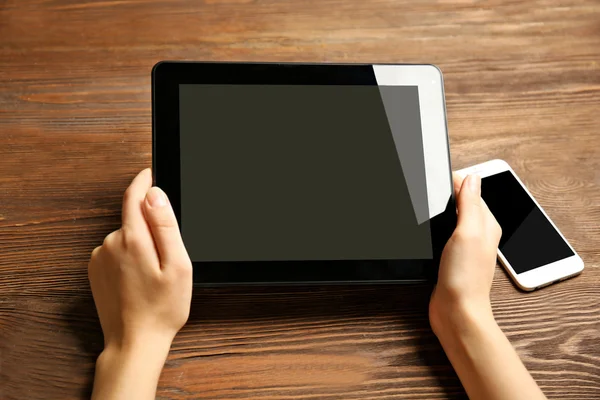 Téléphone portable et les mains féminines en utilisant la tablette — Photo