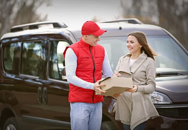 Entrega hombre y mujer recibiendo un paquete —  Fotos de Stock