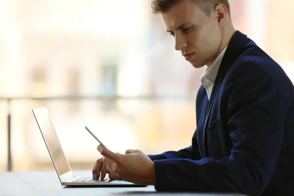 Человек с ноутбуком за столом в офисе — стоковое фото