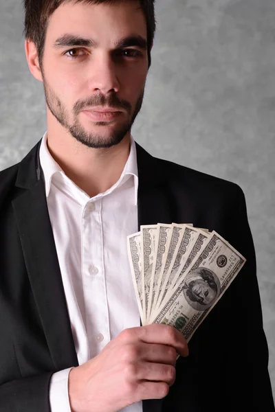 Man in a suit holding dollar banknotes — Stock Photo, Image