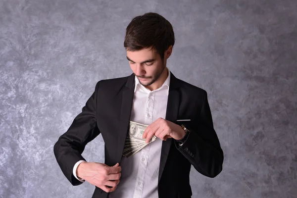 Doları banknot tutan elbiseli adam — Stok fotoğraf