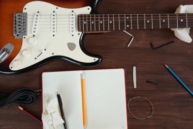 Ahşap masa üstünde defter ile gitar