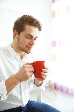 Yakışıklı adam kahve içiyor.