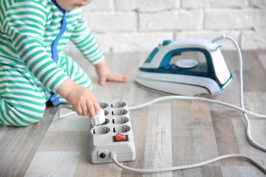 Demir ve elektrik güç çubuğu ile oynayan küçük çocuk evde