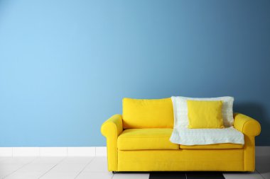 Sarı mavi duvar ackground kanepede