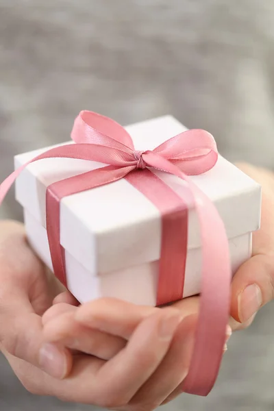 Vrouwelijke handen met kleine geschenk — Stockfoto