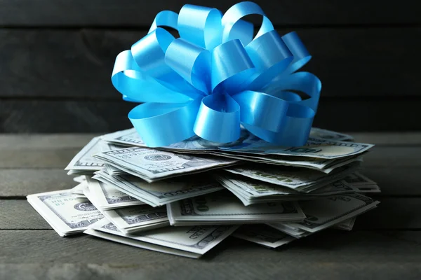 Pile of dollars with bow — Stock Photo, Image