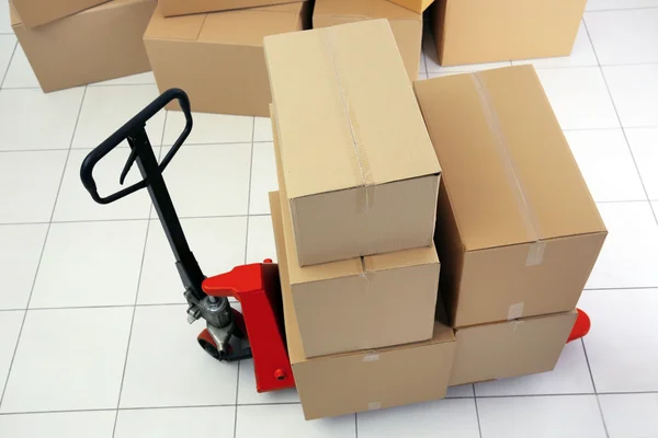 Manual pallet truck with carton boxes — Stock Photo, Image