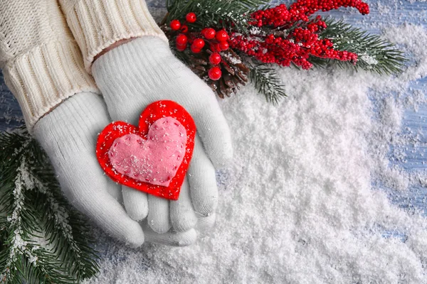 Hands in mittens with decorative heart — Stock Photo, Image