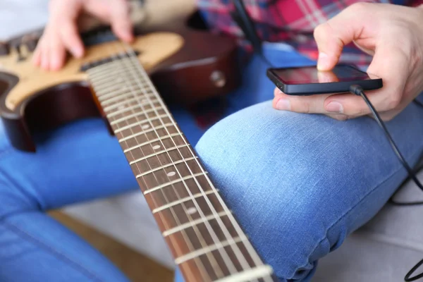 Człowiek z gitara elektryczna i telefon — Zdjęcie stockowe