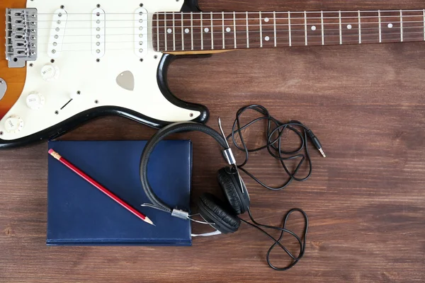 Guitar with headphones and notebook — Stock Photo, Image