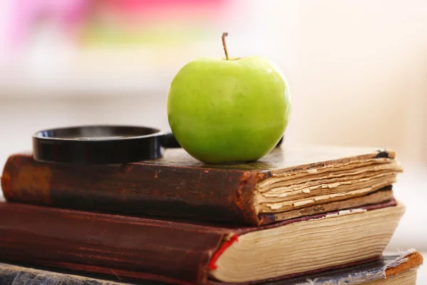 Libros y manzana sobre la mesa — Foto de Stock