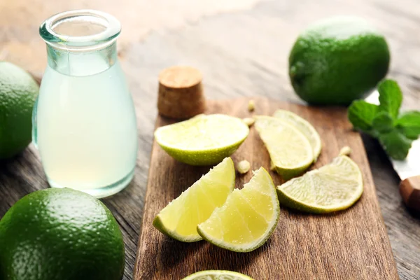 Fresh limes on cutting board — Stock Photo, Image