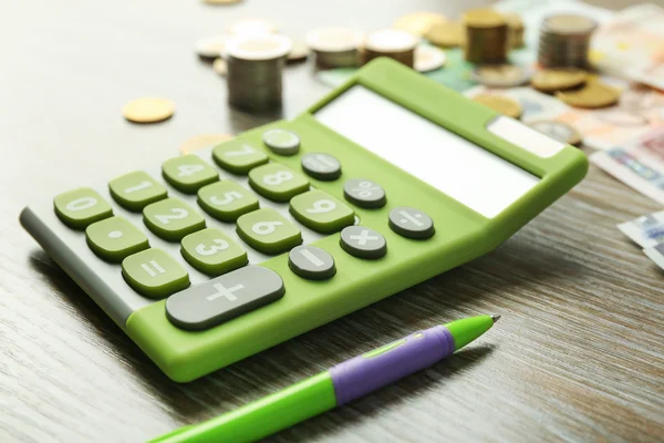 Зелений калькулятор з банкнотами — стокове фото