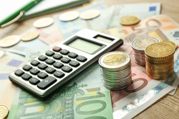 Grey calculator with coins and notebook — Stock Photo, Image