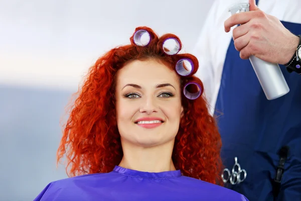 Schönes Mädchen macht Lockenwickler im Friseursalon — Stockfoto