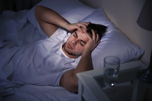 Young man holding his head — Stock Photo, Image