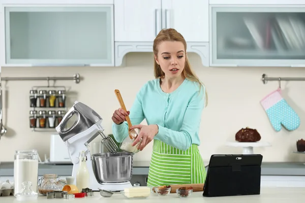 Frau benutzt Computer, um einem Rezept zu folgen — Stockfoto