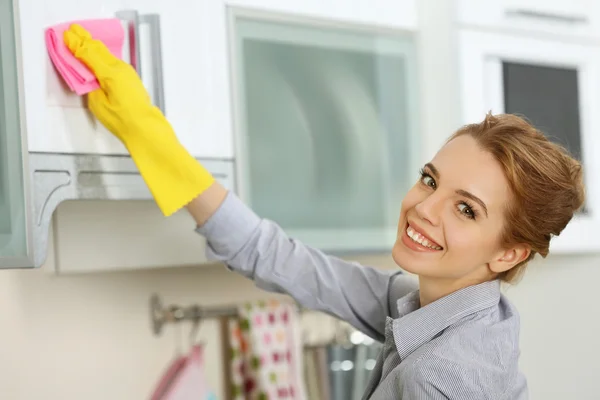 Woman scrubbing the kitchen cupboard — Stock Photo, Image