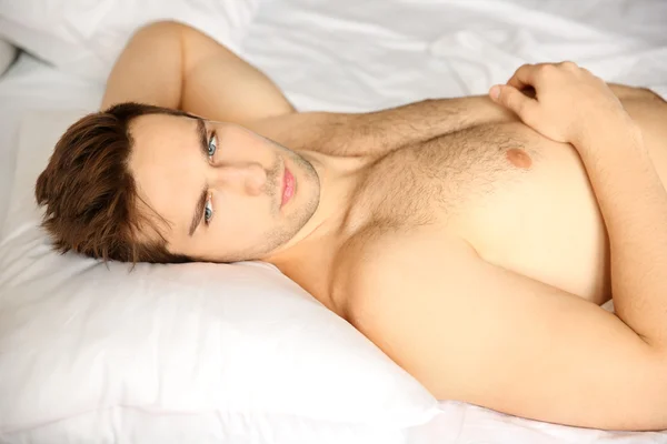 Junger Mann liegt im Bett — Stockfoto