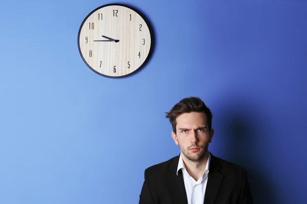 Man in staande naast een grote klok — Stockfoto
