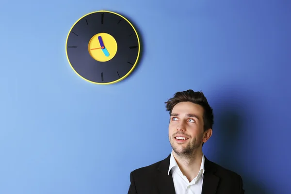 Hombre de pie al lado de un gran reloj — Foto de Stock