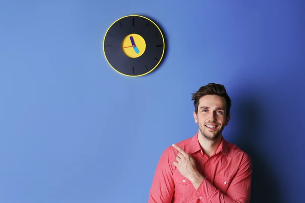 Człowiek stojący obok zegara — Zdjęcie stockowe