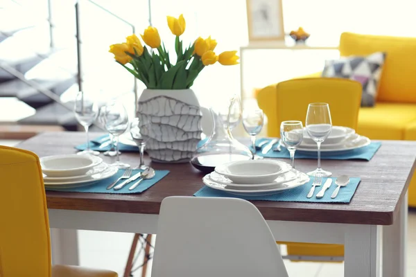 Tisch serviert mit Gerichten und einem Strauß — Stockfoto