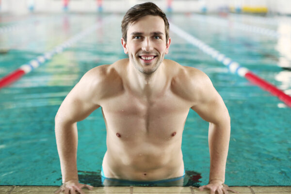 Красивый спортсмен в бассейне
