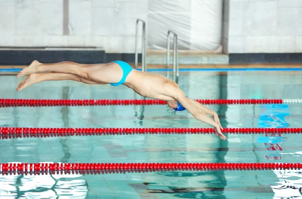 Sporty young man jumping into water — Stock Photo, Image