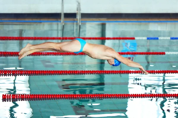 Спортивный молодой человек прыгает в воду — стоковое фото