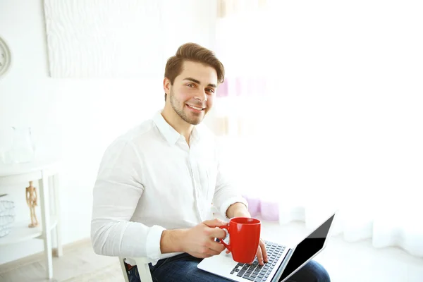 Laptop ve kahve tutan adam — Stok fotoğraf