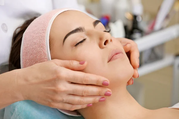 Jonge vrouw met gezicht massage — Stockfoto