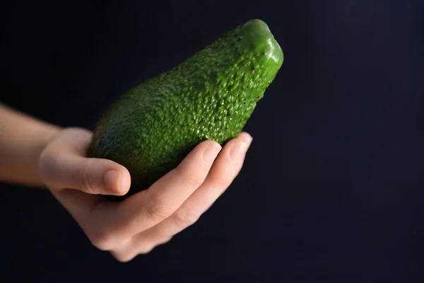 Female hand holding avocado — Stock Photo, Image