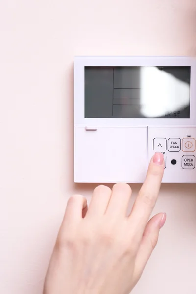 Mujer cambiando un termostato digital —  Fotos de Stock