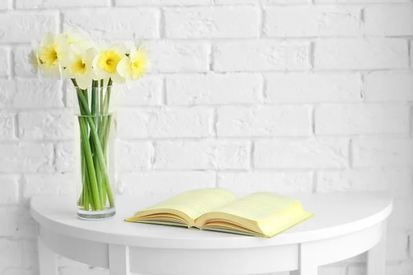 Flores frescas de narciso e livro aberto — Fotografia de Stock