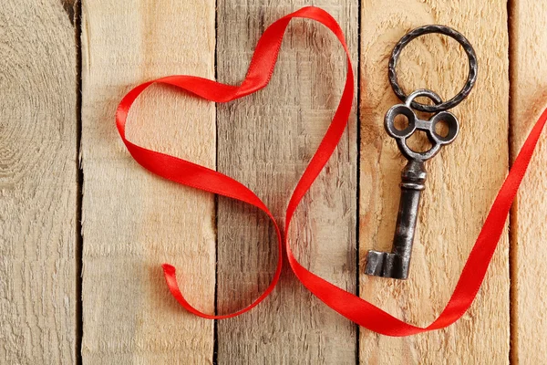 Old key and red ribbon — Stock Photo, Image