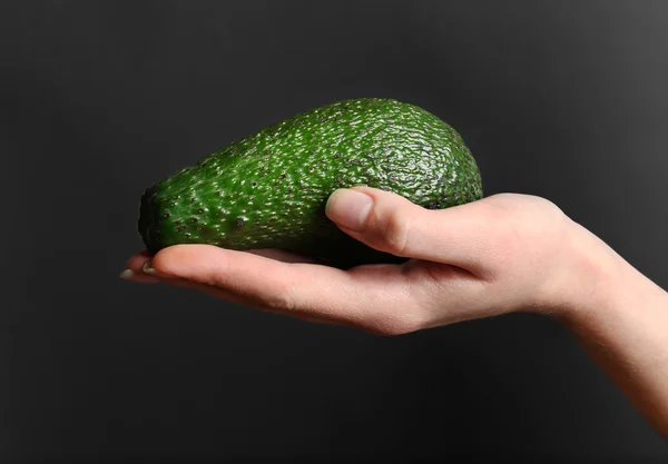 Female hand holding avocado — Stock Photo, Image