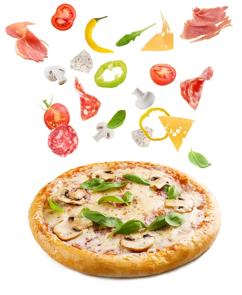 Tasty pizza with falling vegetables — Stock Photo, Image